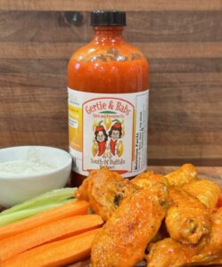 Buffalo wings with hot sauce and sides.