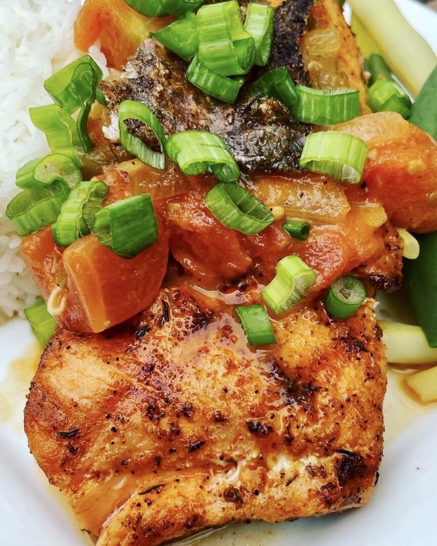 A plate of salmon, rice, and vegetables.